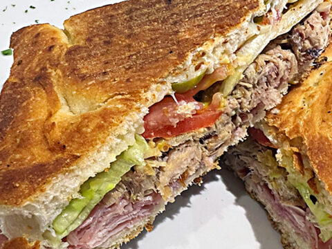 Cuban Sandwich. Focaccia bread with Parmacotto, roasted pork, swiss, pickles, lettuce, tomato, mustard